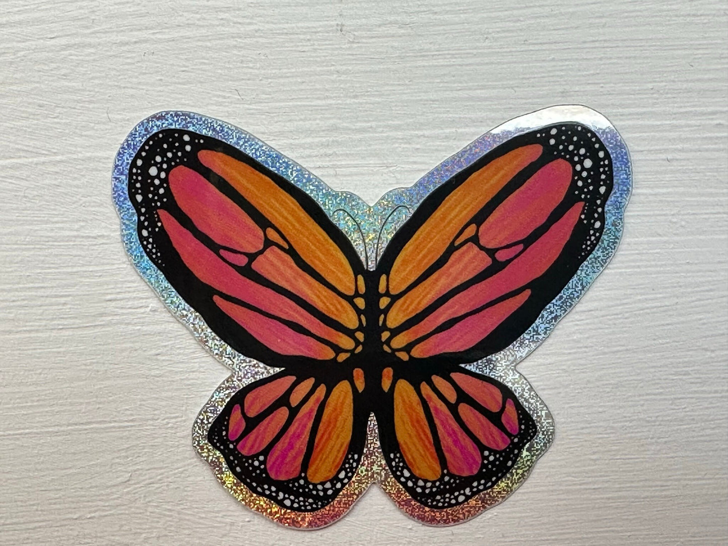 Butterfly Sticker - Pixie Dust Sticker of a Monarch Butterfly Electric Orange wings with dots on the ends  showing a multi-colored pattern