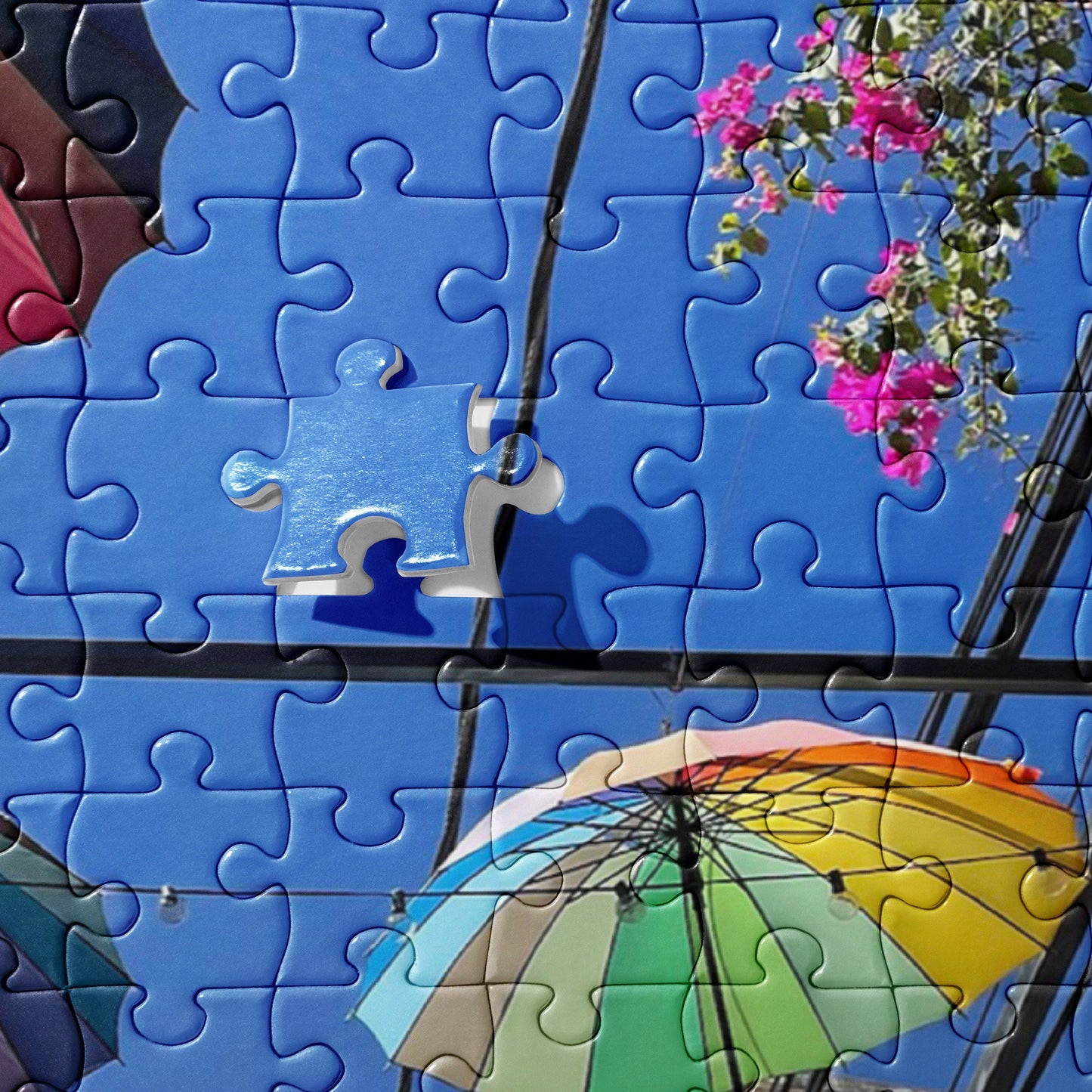 Jigsaw puzzle of Rainbow Parasols hung up in an alley with flowers in the Dominican Republic in Puerto Plata
