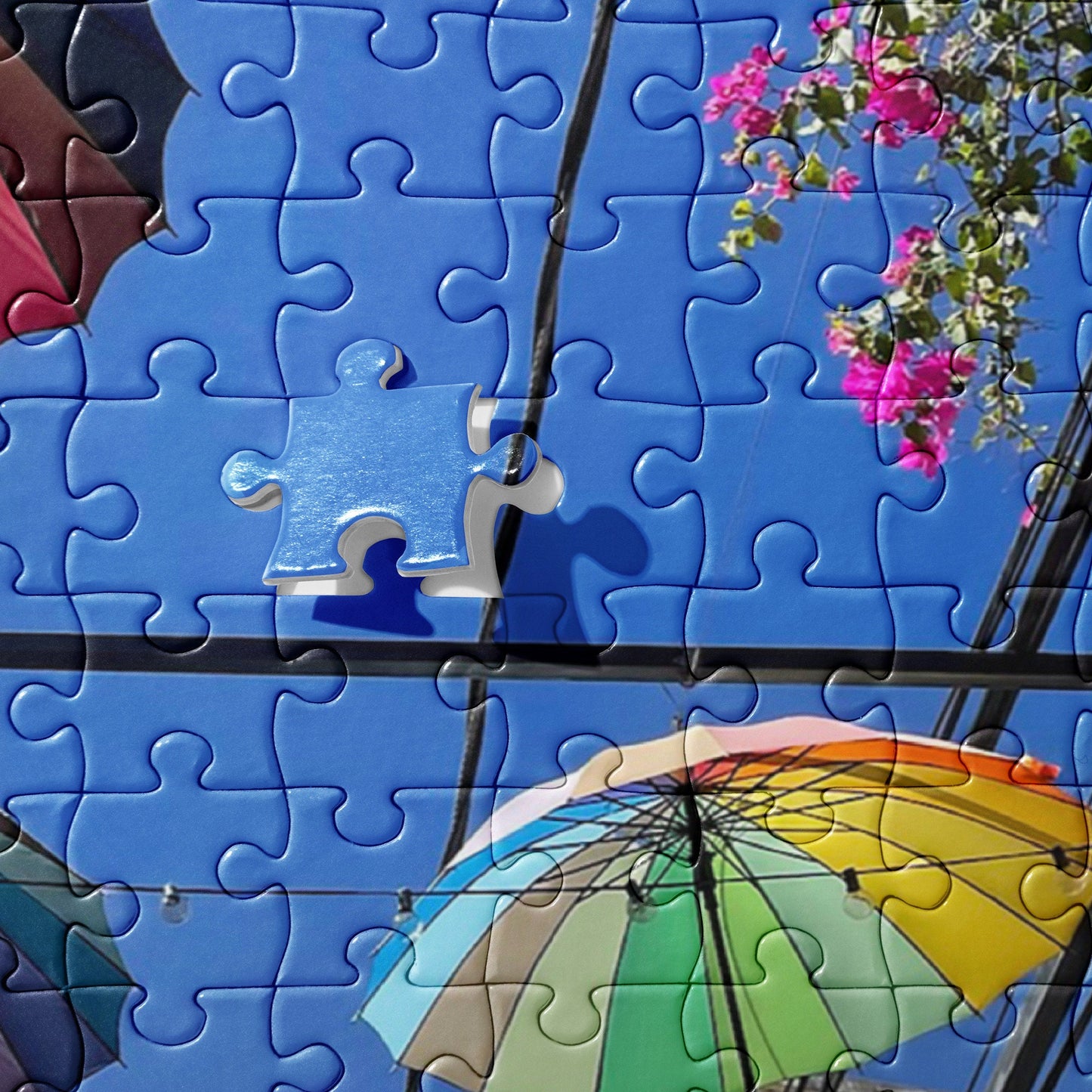 Jigsaw puzzle of Rainbow Parasols hung up in an alley with flowers in the Dominican Republic in Puerto Plata
