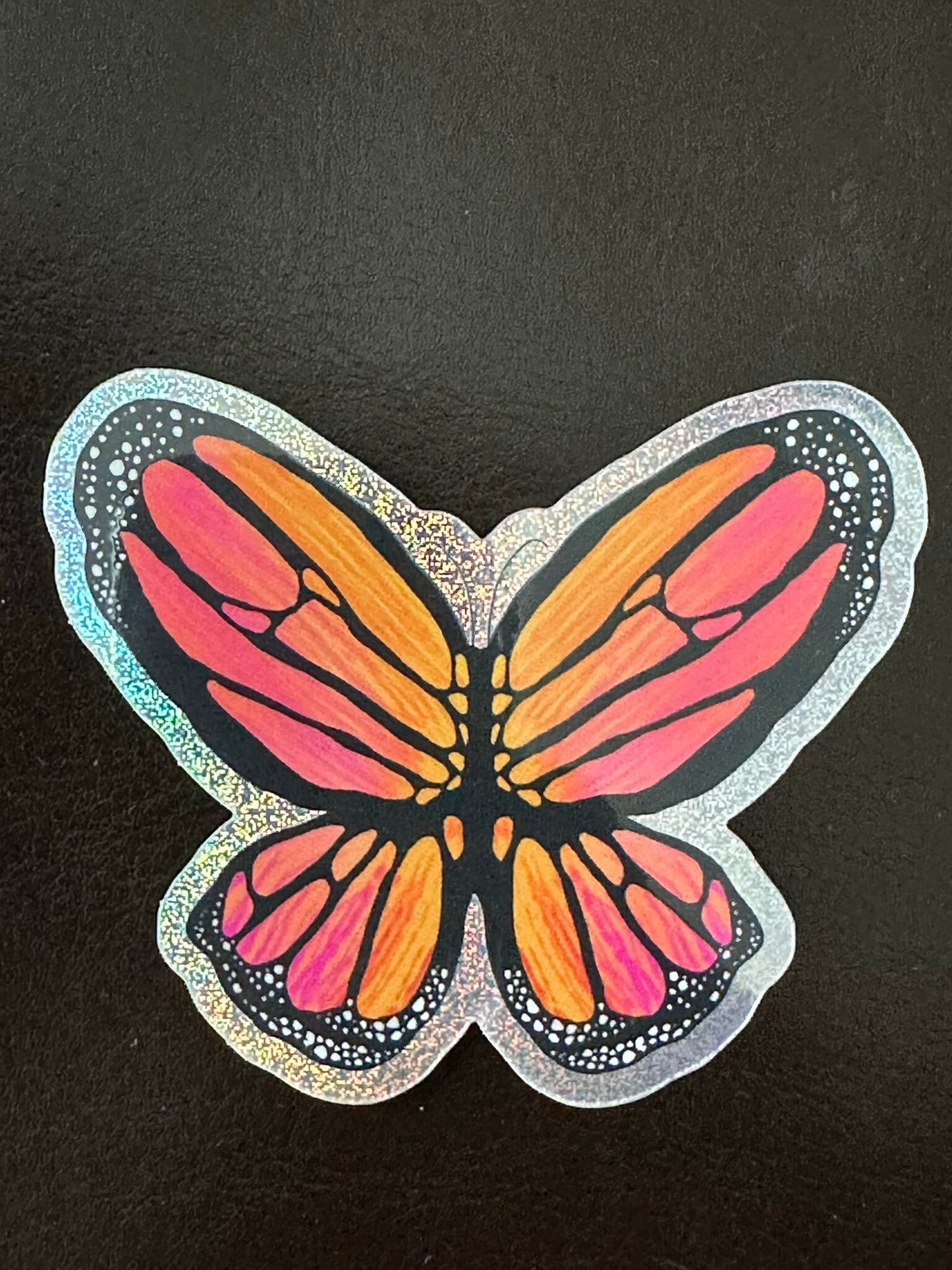 Butterfly Sticker - Pixie Dust Sticker of a Monarch Butterfly Electric Orange wings with dots on the ends  showing a multi-colored pattern