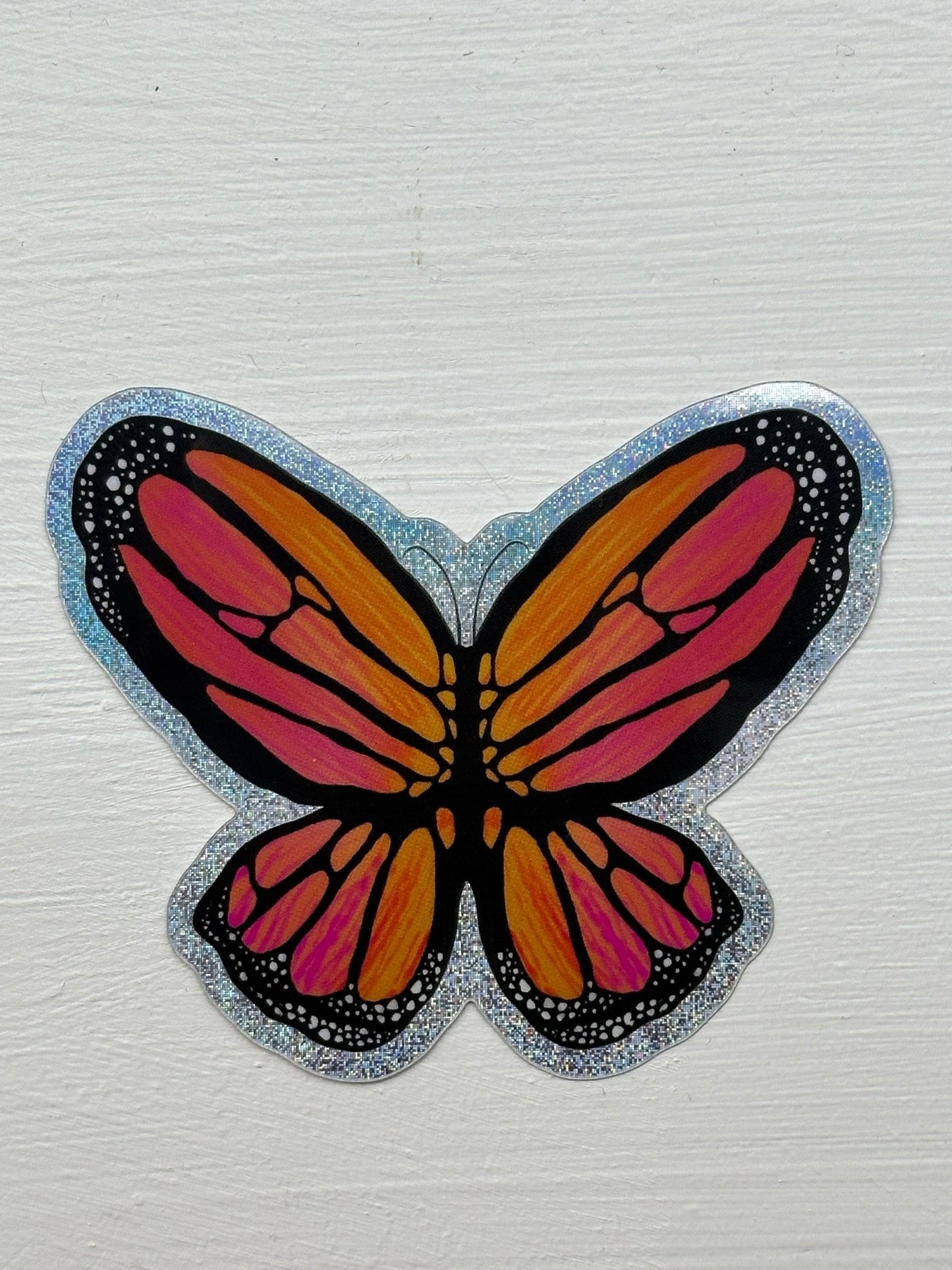Butterfly Sticker - Pixie Dust Sticker of a Monarch Butterfly Electric Orange wings with dots on the ends  showing a multi-colored pattern